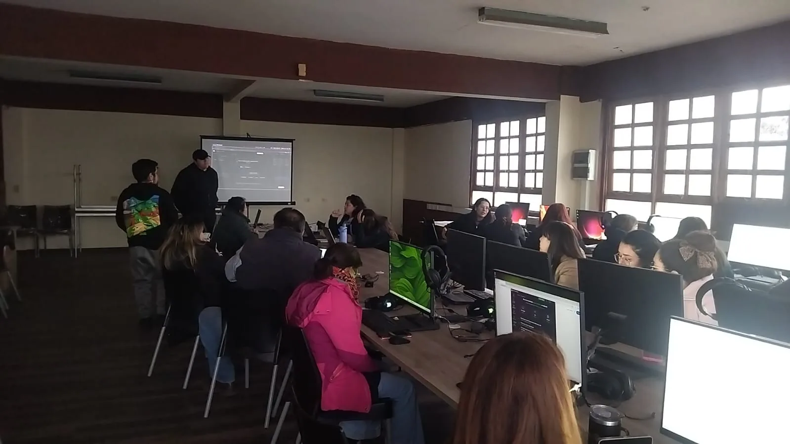Equipo de AMPLIA guía una actividad proyectada frente a la comunidad educativa