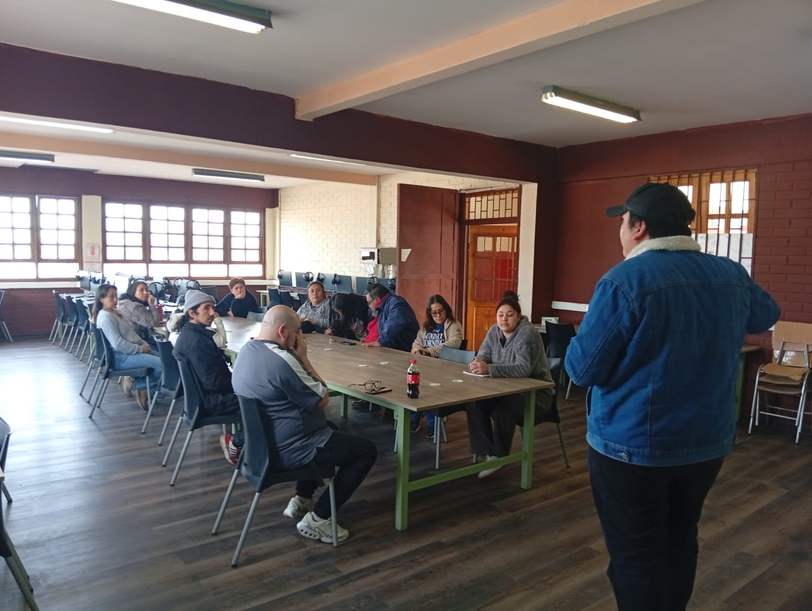 Facilitador conversa con apoderados y vecinos durante el primer taller de Amplia en el Colegio Quitalmahue